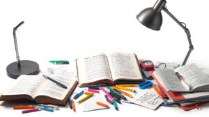 Een rommelig bureau met studiematerialen en notities.